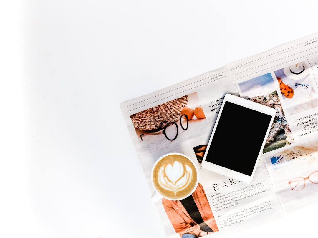 Newspaper and digital tablet showing news articles side by side